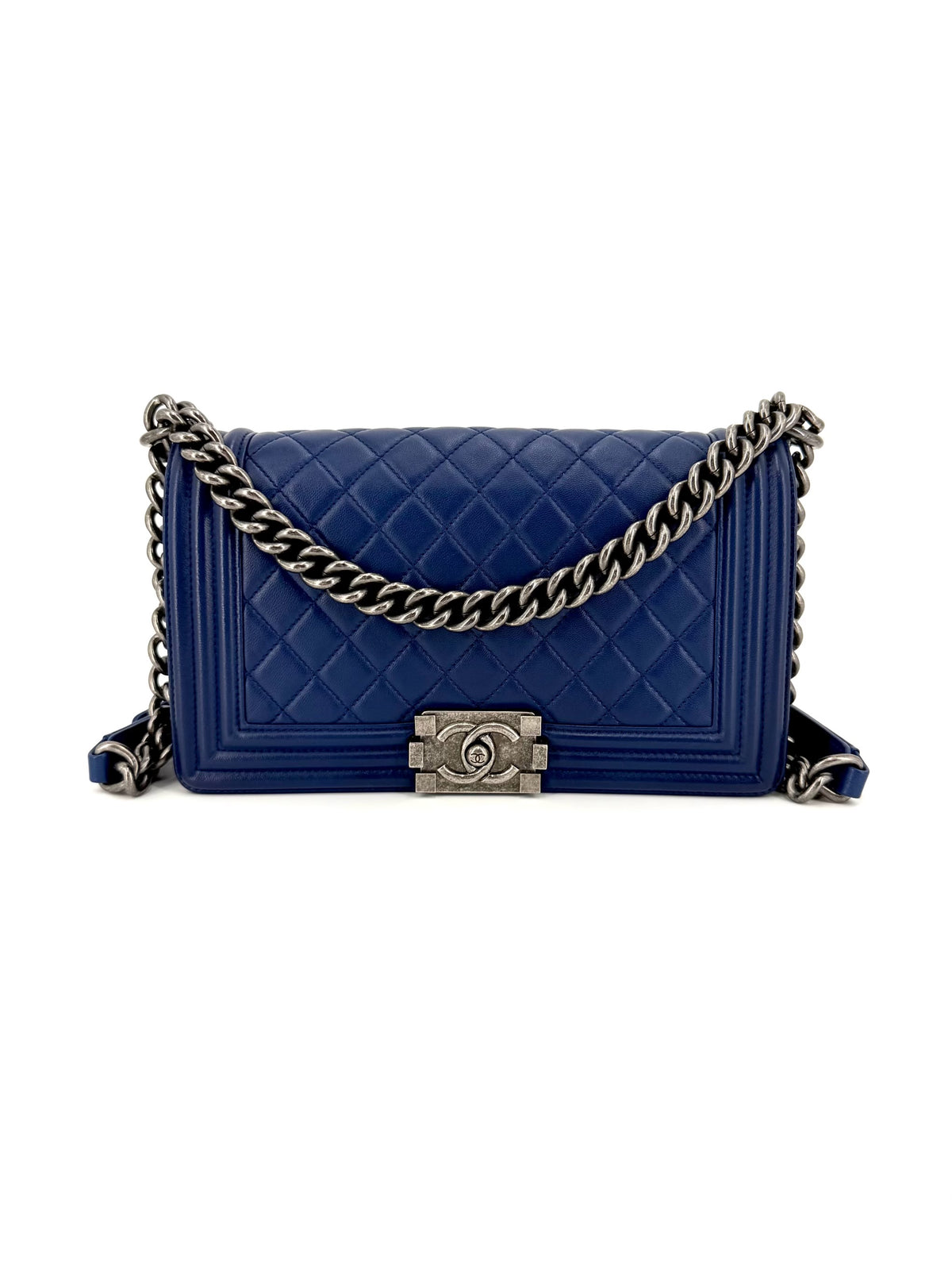 Authentic Chanel Boy Medium flap bag in rich blue diamond-quilted leather with dark ruthenium-tone chain hardware, structured silhouette, and signature Boy push-lock closure.