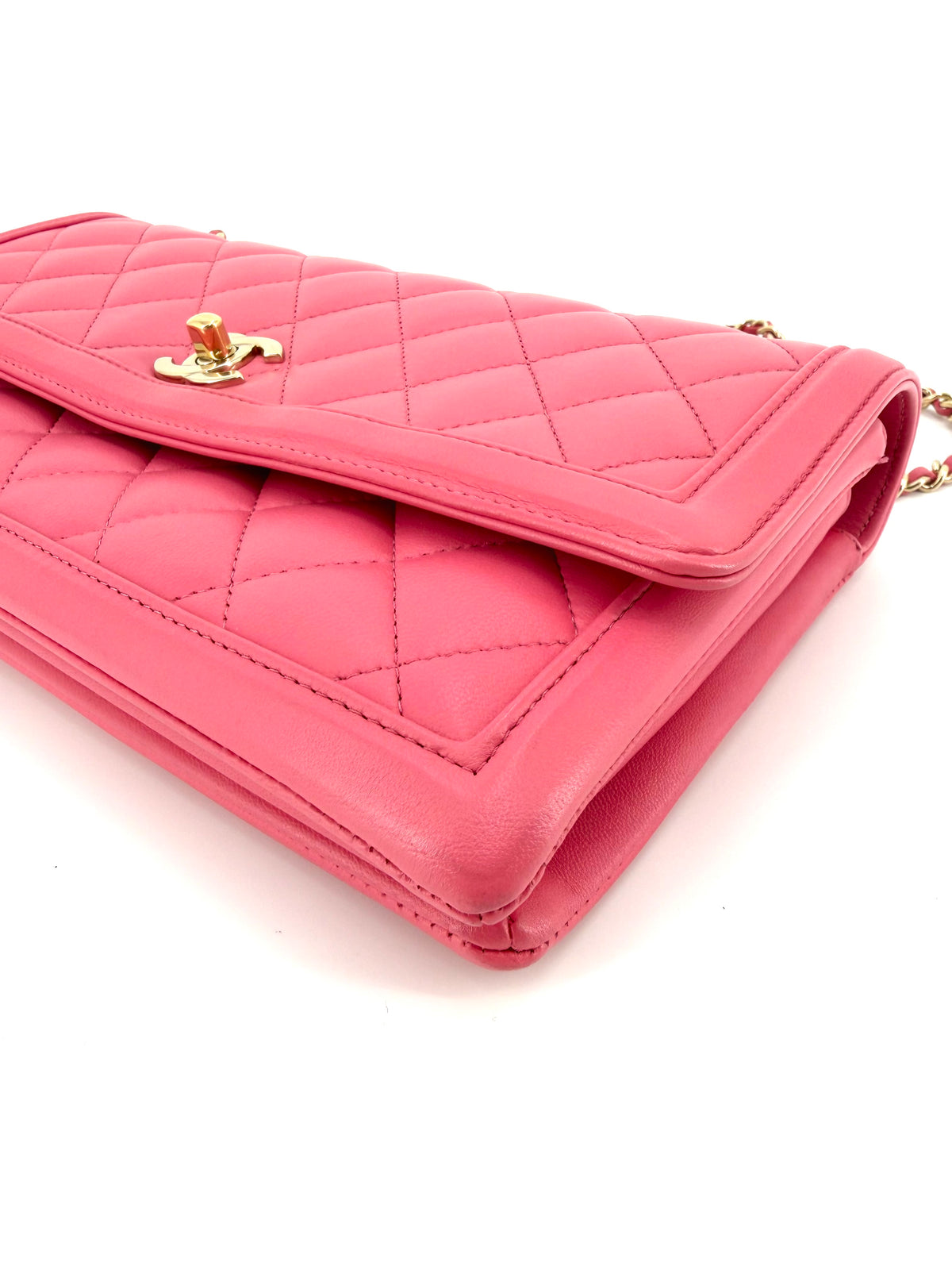 Chanel pink diamond-quilted East-West flap bag featuring gold-tone CC turnlock closure, leather-interwoven chain strap, and three-compartment design.