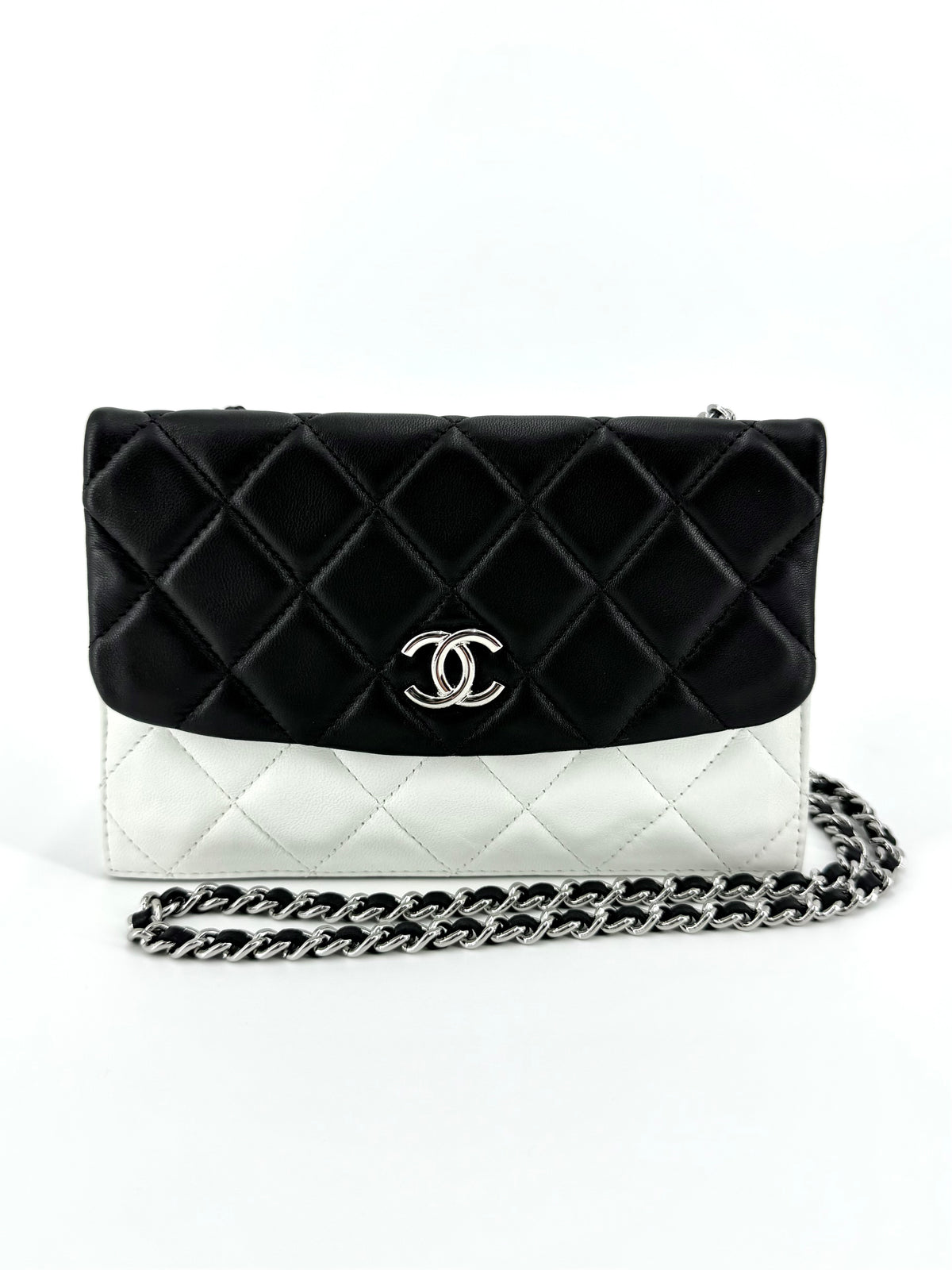 Chanel black and white lambskin leather handbag with silver-tone hardware and two separate flap compartments.