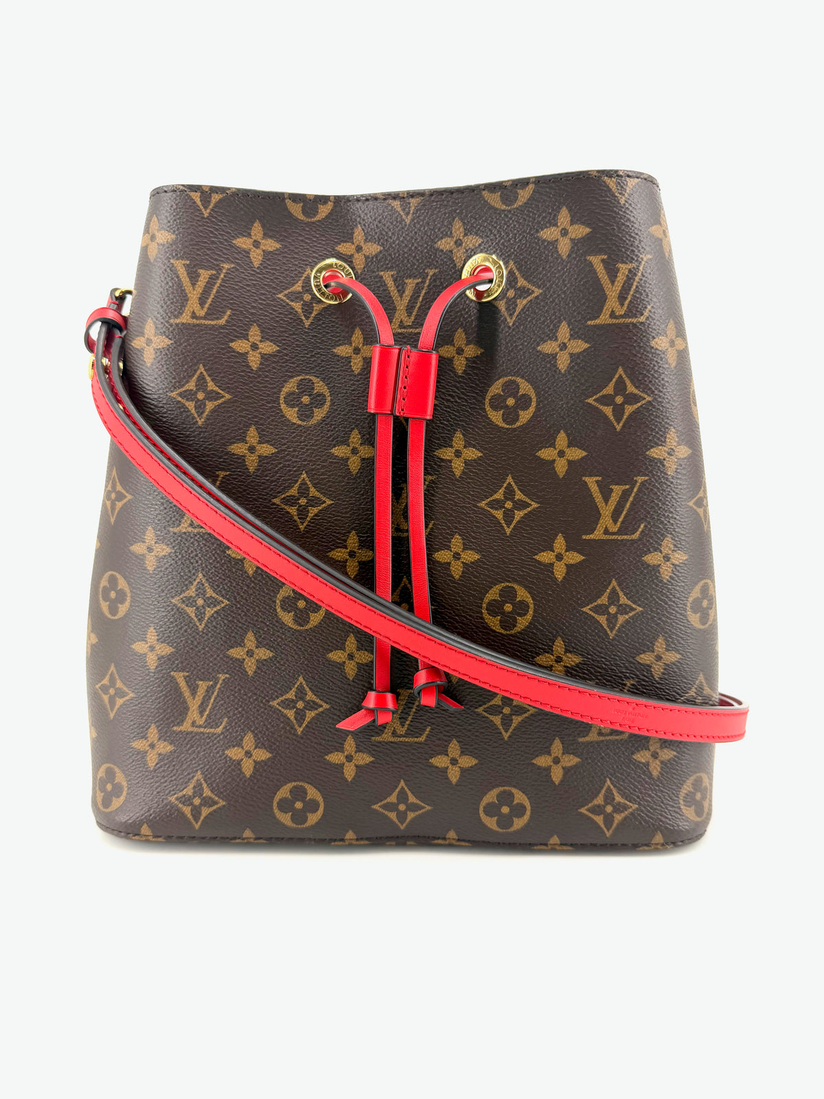Authentic Louis Vuitton Néonoé MM bucket bag in brown Monogram canvas with vibrant red leather drawstring, matching red shoulder strap, and gold-tone hardware.